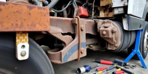 Close-up of a damaged truck frame with repair tools.