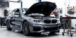 BMW vehicle in a service bay, mechanics at work.